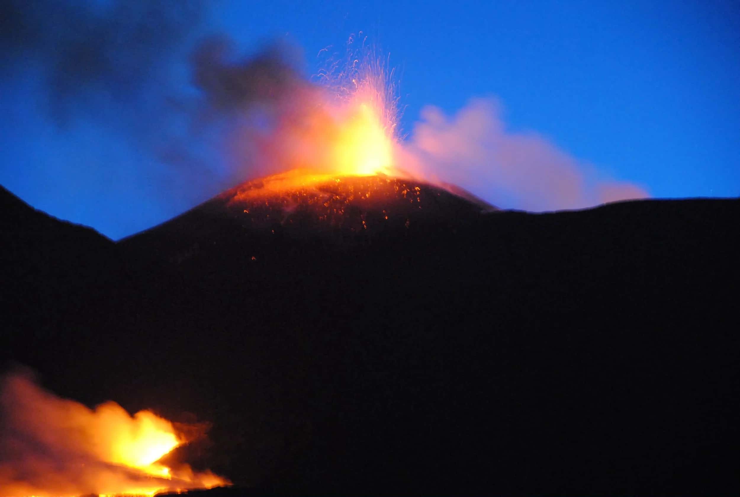 Eruzione notturna dell'Etna: fontana di lava dal cratere e colata incandescente